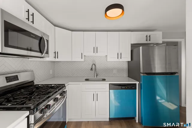 a kitchen with stainless steel appliances granite countertop a stove a refrigerator and a sink