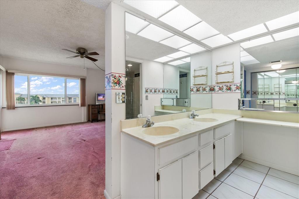 401 150th Avenue, Unit 251 Madeira Beach, FL 33708 - Photo 28 of 45 a bathroom with a granite countertop sink mirror and a bath tub
