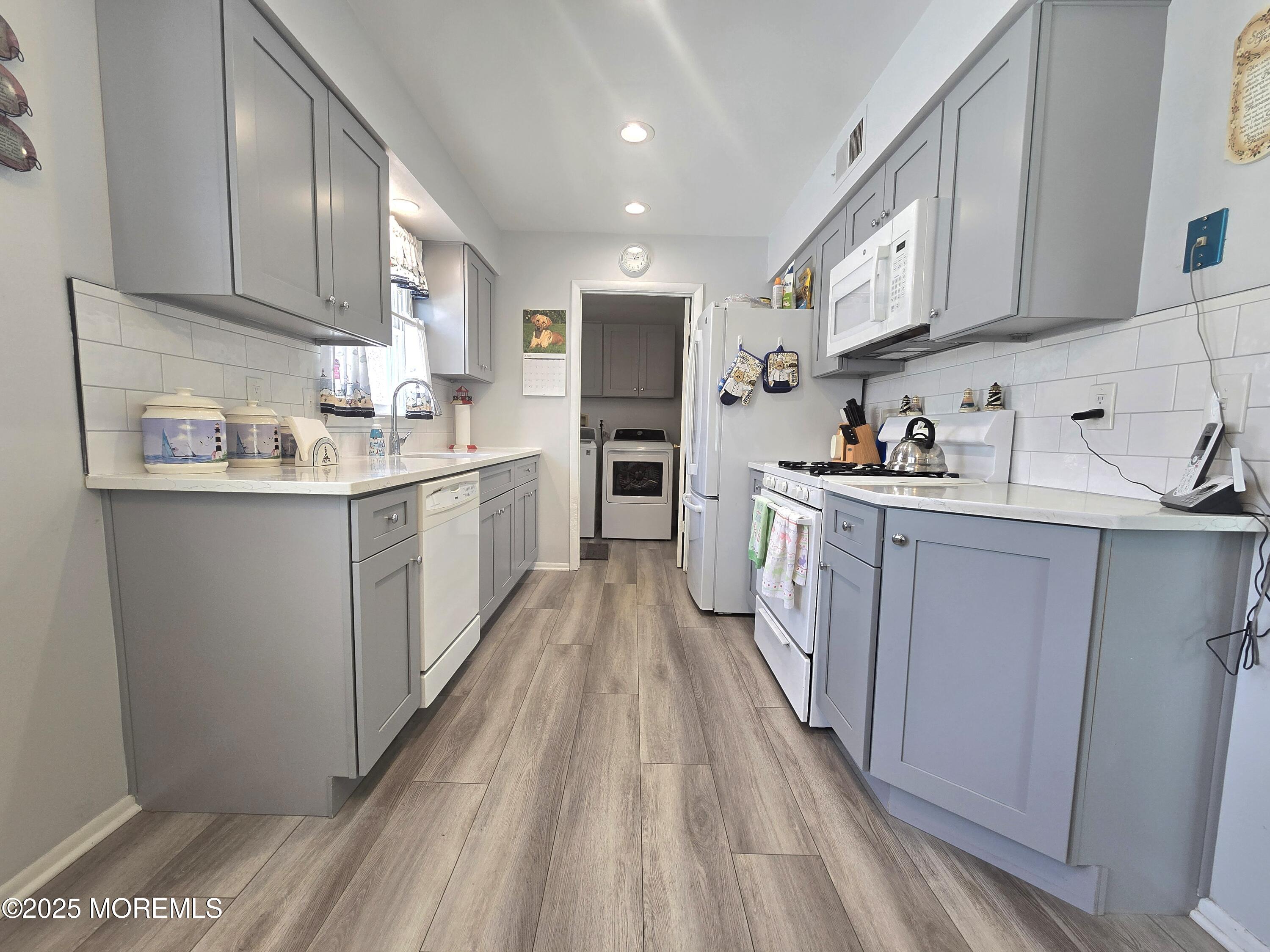 2126 Wainwright Road Toms River, NJ 08753 - Photo 28 of 28 a kitchen with kitchen island a sink a stove oven cabinets and wooden floor