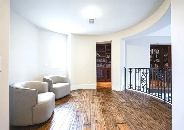 a view of staircase with lots of frames on wall and a large window