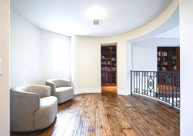 a view of staircase with lots of frames on wall and a large window