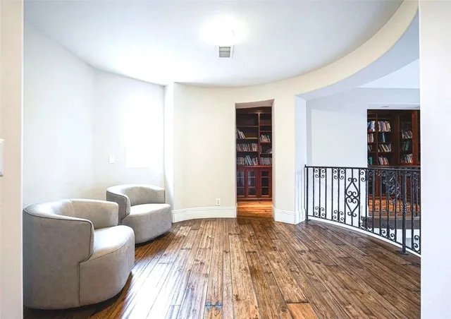 a view of staircase with lots of frames on wall and a large window