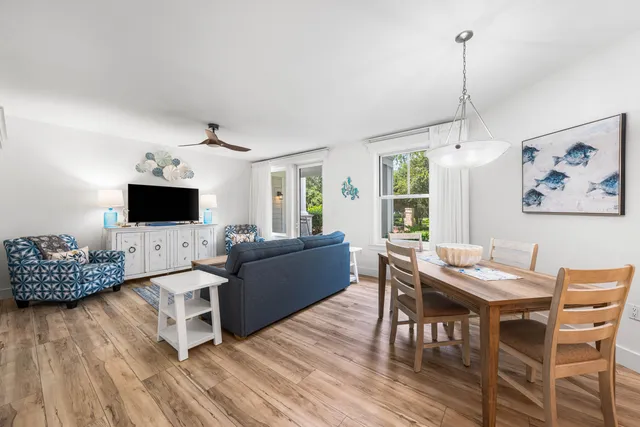 a living room with furniture a flat screen tv and a wooden floor
