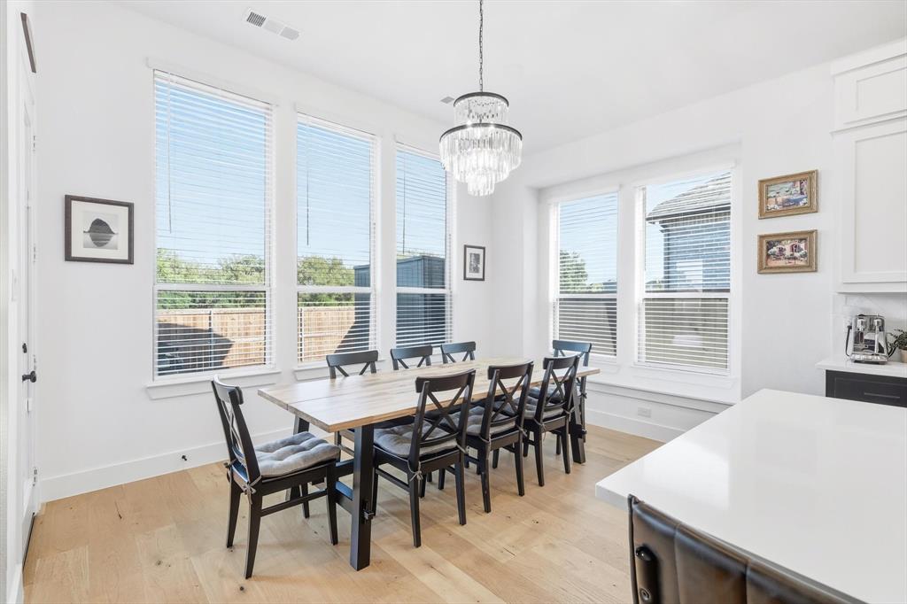 4608 Mount Vista Road Oak Point, TX 75068 - Photo 25 of 39 Dining area featuring a modern chandelier, light wood-finish flooring, and bright white walls