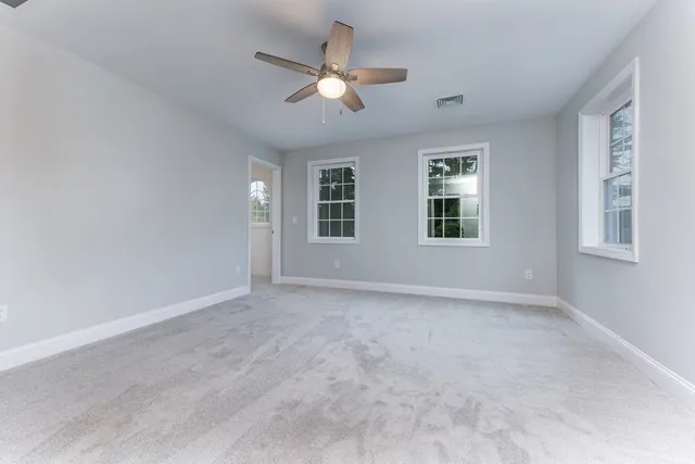 a bathroom with a granite countertop sink a toilet and a mirror