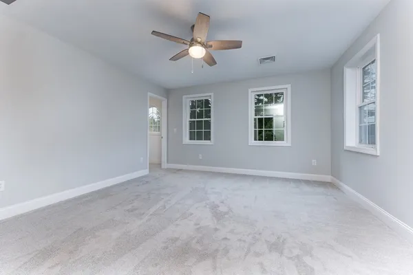 a bathroom with a granite countertop sink a toilet and a mirror