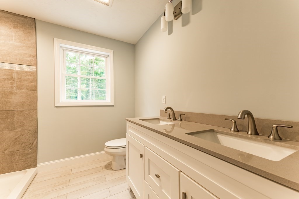 119 County Road Marion, MA 02738 - Photo 9 of 13 a bathroom with a granite countertop sink a toilet and a mirror