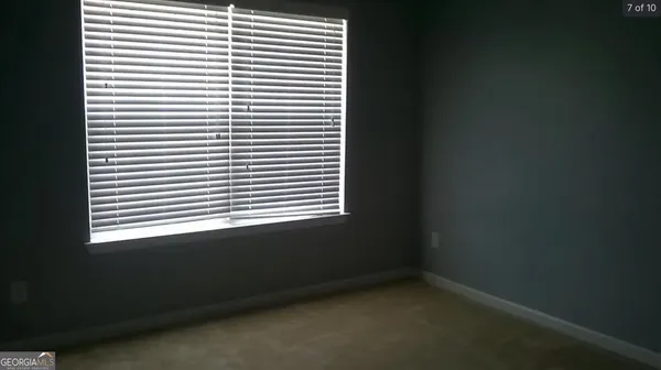 a view of kitchen with white cabinet and a window