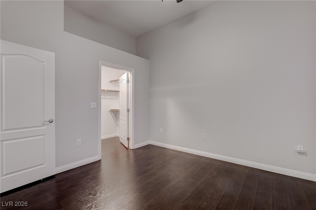 2305 West Horizon Ridge Parkway, Unit 3921 Henderson, NV 89052 - Photo 8 of 31 Unfurnished bedroom featuring a walk in closet, dark wood finished floors, and a closet