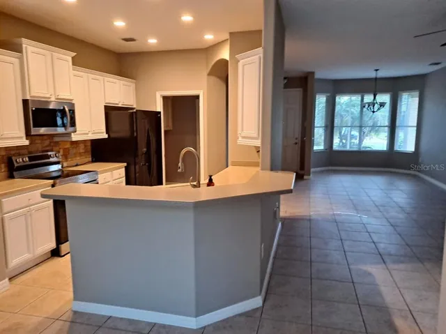 a kitchen with stainless steel appliances a sink a stove a microwave a sink a refrigerator and cabinets