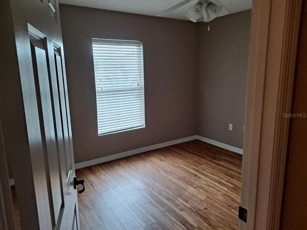 13534 Biscayne Grove Lane Grand Island, FL 32735 - Photo 6 of 12 a view of an empty room with wooden floor and a window