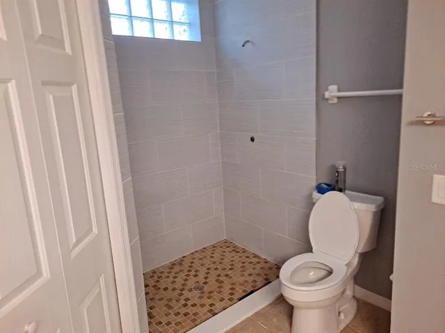 a bathroom with a toilet and a shower
