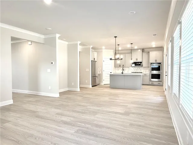 a view of a kitchen with wooden floor and a window