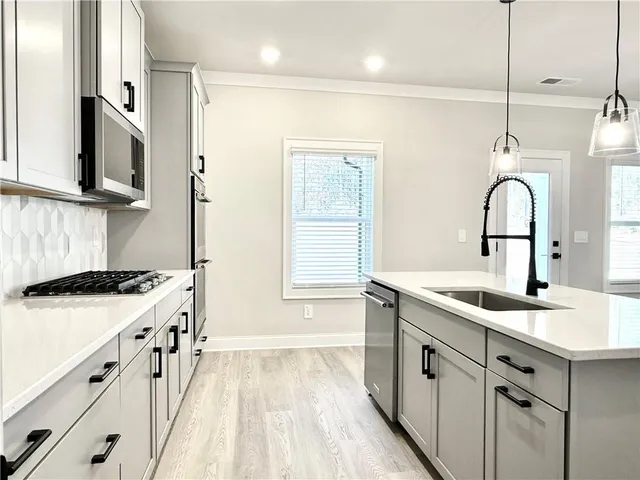 a kitchen with a sink stove and cabinets
