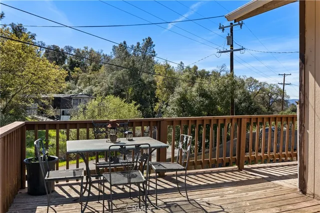 a balcony with wooden floor table and chairs