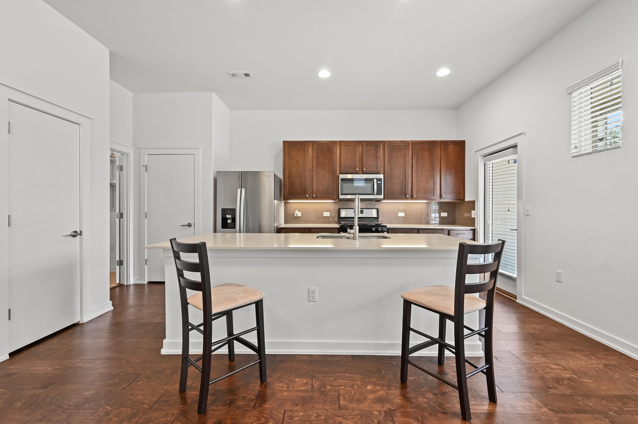 8901 Parker Ranch Circle, Unit A Austin, TX 78748 - Photo 11 of 31 Warm hardwood floors contrast with clean white walls and rich wood cabinetry.