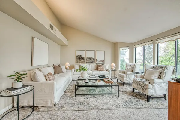 a living room with furniture and large windows