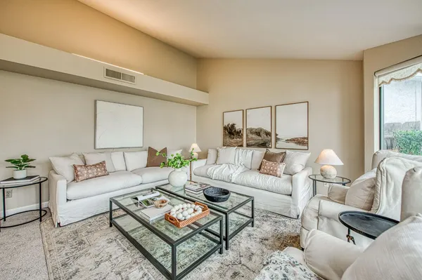 a living room with furniture a rug and a large window