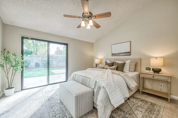 a bedroom with a large bed and a chandelier fan