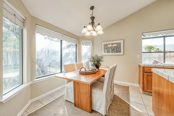 a dining room with furniture a chandelier and wooden floor