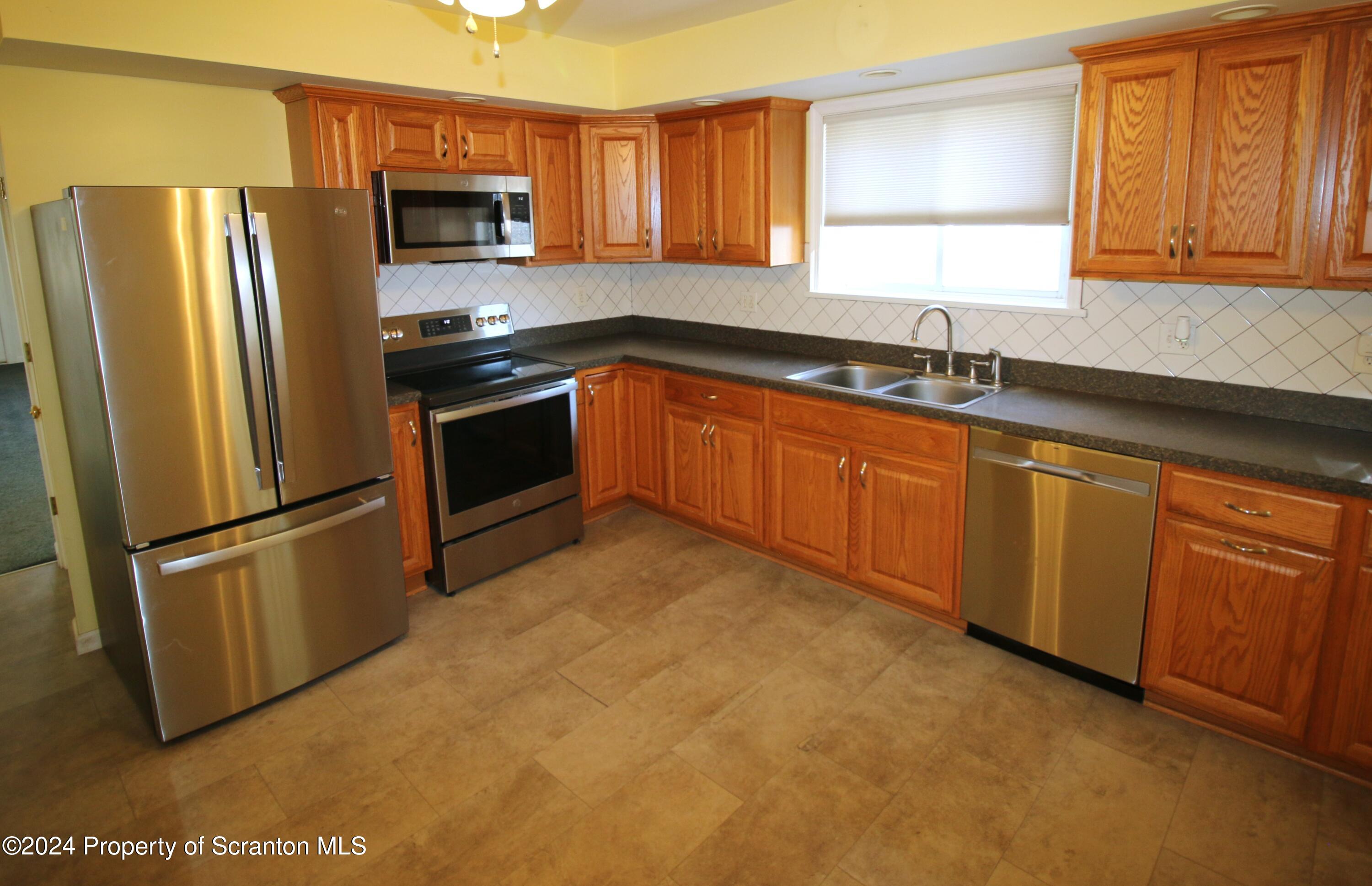 1105 Rundle Street Scranton, PA 18504 - Photo 11 of 30 a kitchen with stainless steel appliances granite countertop a refrigerator sink and microwave