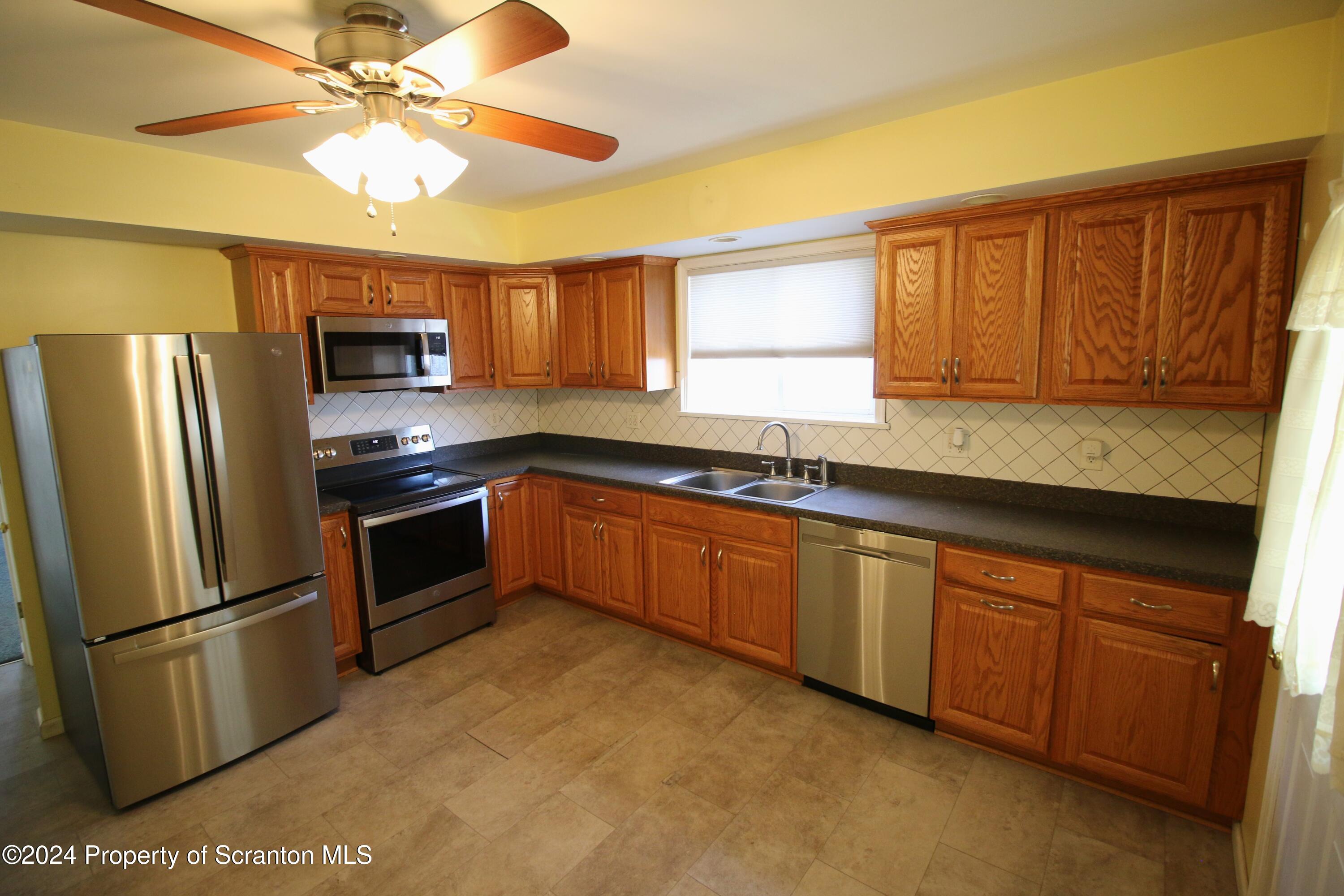 1105 Rundle Street Scranton, PA 18504 - Photo 12 of 30 a kitchen with stainless steel appliances granite countertop a refrigerator a sink a stove a microwave and island