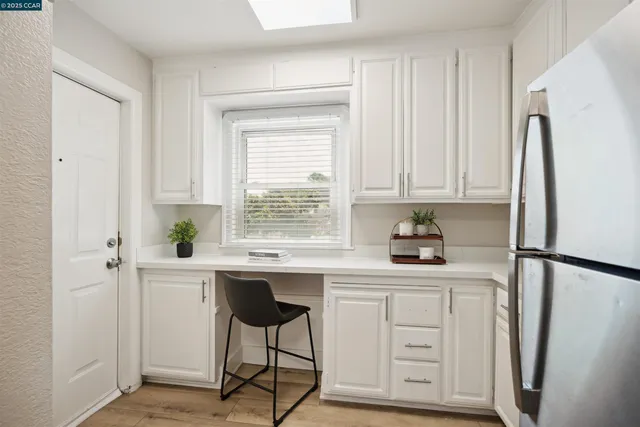 a kitchen with stainless steel appliances a white cabinets and a refrigerator