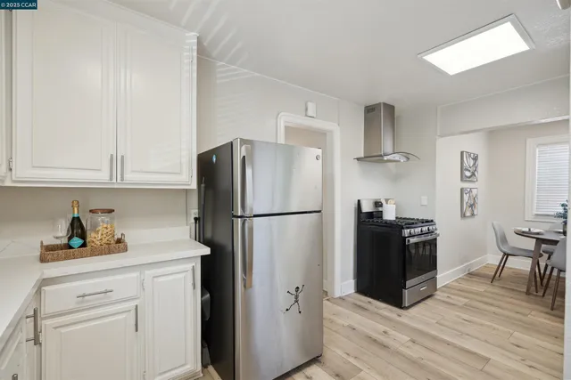 a kitchen with a refrigerator cabinets and wooden floor