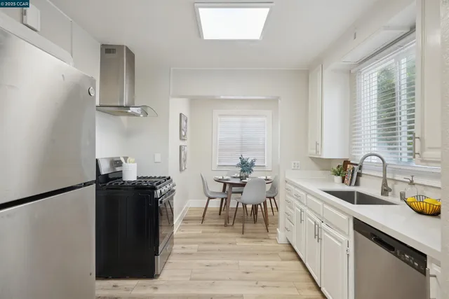 a kitchen with sink and view of living room
