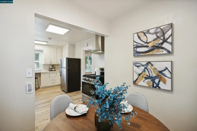 a kitchen with stainless steel appliances a refrigerator and a dining table