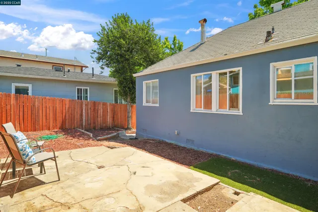 a view of backyard with wooden fence and seating space