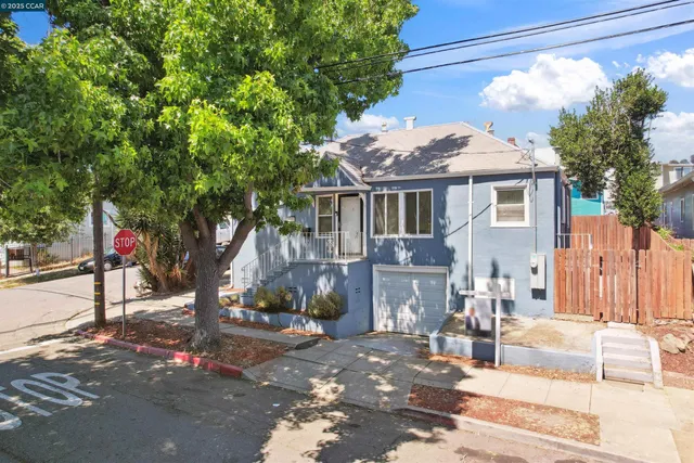 a front view of a house with a tree