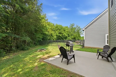a view of a chairs and table in patio next to a yard