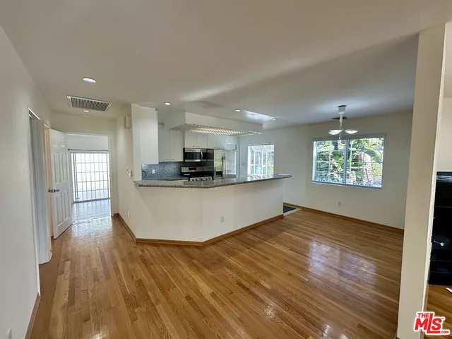 a view of kitchen and hall with wooden floor and windows