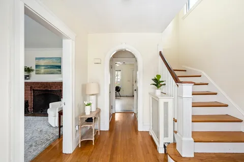 a view of a hallway with wooden floor and staircase