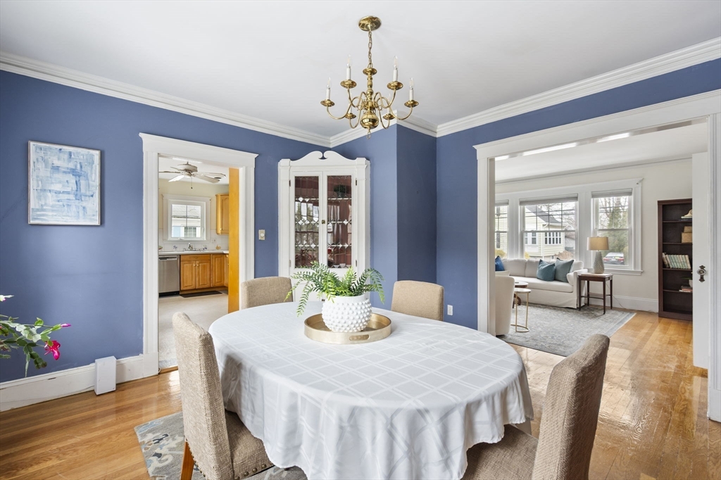 71 Governors Road Milton, MA 02186 - Photo 10 of 25 a dining room with wooden floor a chandelier a wooden table and chairs