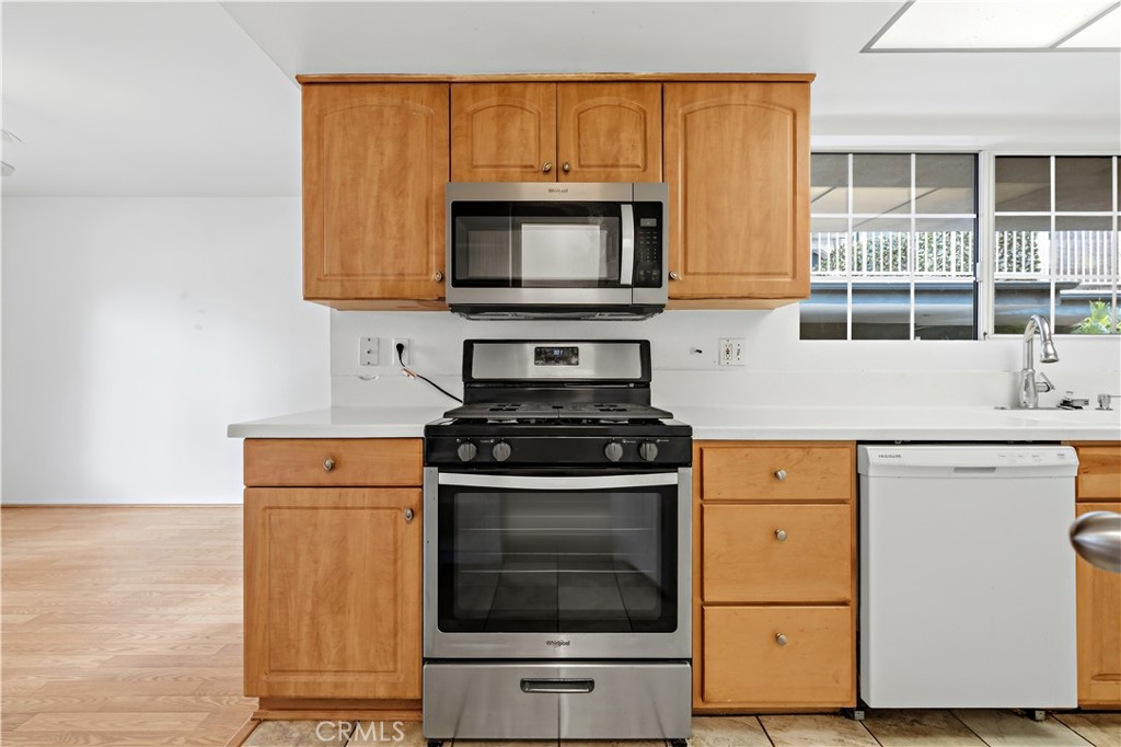 8317 College Avenue Whittier, CA 90605 - Photo 12 of 41 a kitchen with stainless steel appliances granite countertop a stove and a microwave