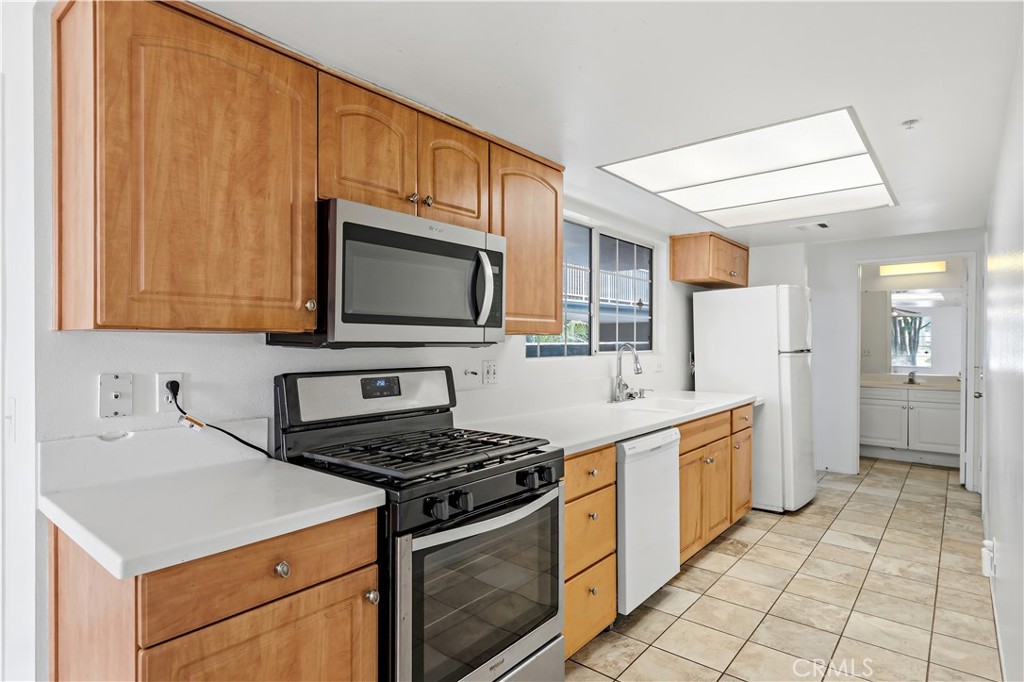 8317 College Avenue Whittier, CA 90605 - Photo 16 of 41 a kitchen with stainless steel appliances a stove microwave and cabinets