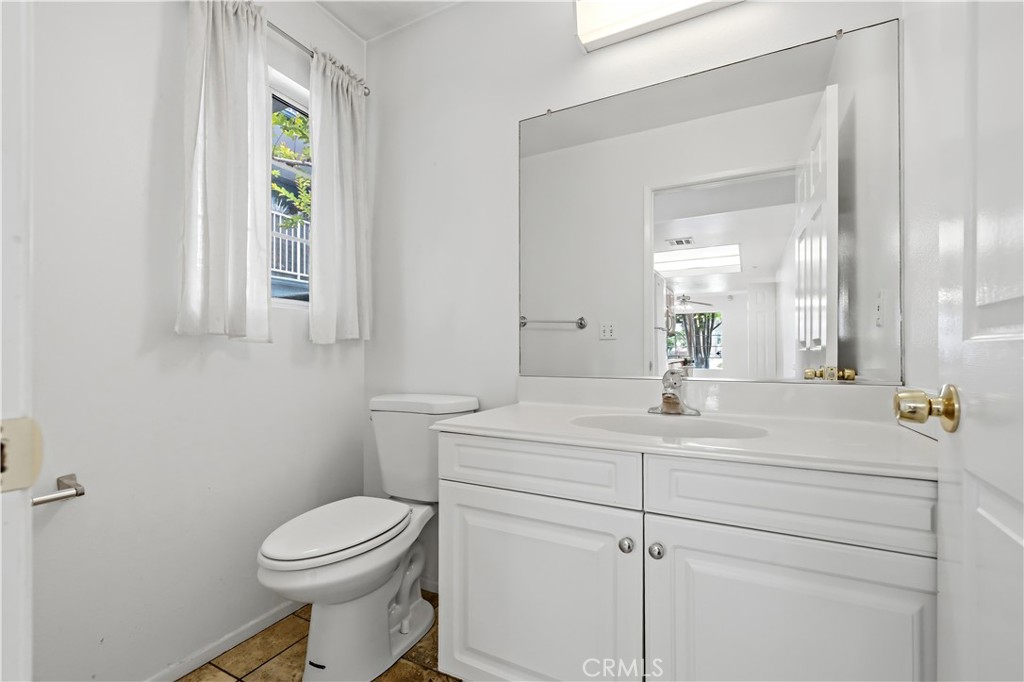 8317 College Avenue Whittier, CA 90605 - Photo 17 of 41 a bathroom with a sink a toilet and mirror