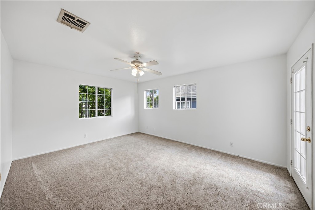 8317 College Avenue Whittier, CA 90605 - Photo 24 of 41 an empty room with windows and chandelier fan