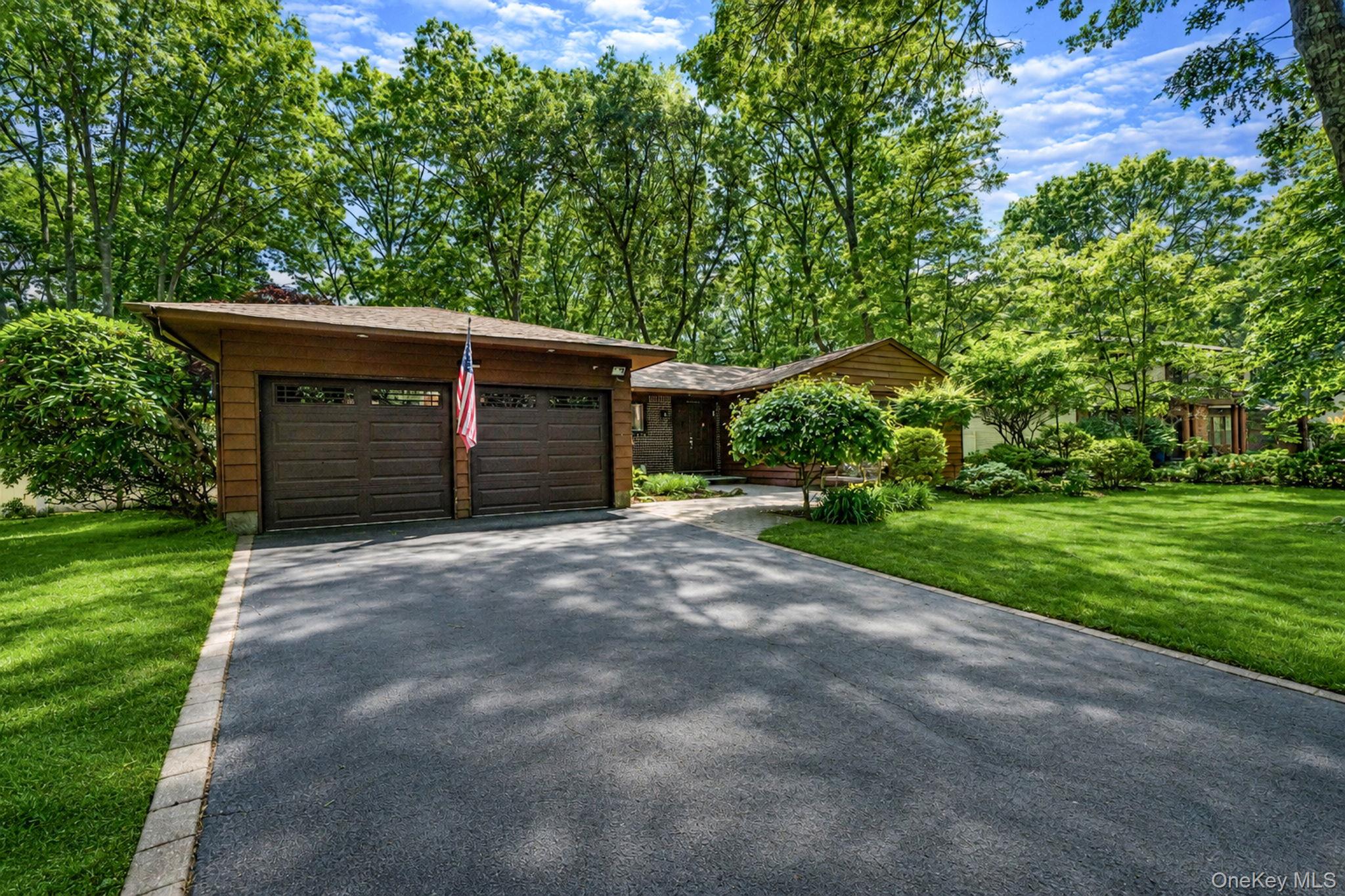 96 Fulton Boulevard Commack, NY 11725 - Photo 2 of 41 a front view of a house with a yard and garage
