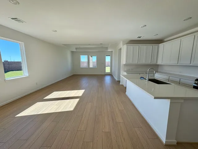 a kitchen with stainless steel appliances granite countertop a sink a stove a refrigerator and cabinets