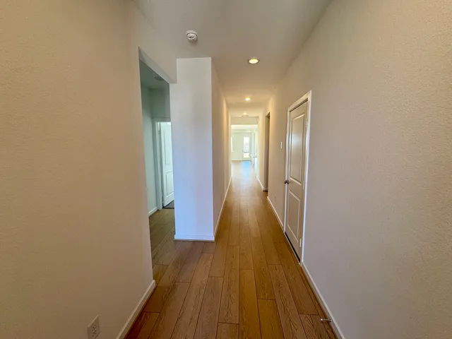 a view of a hallway with wooden floor