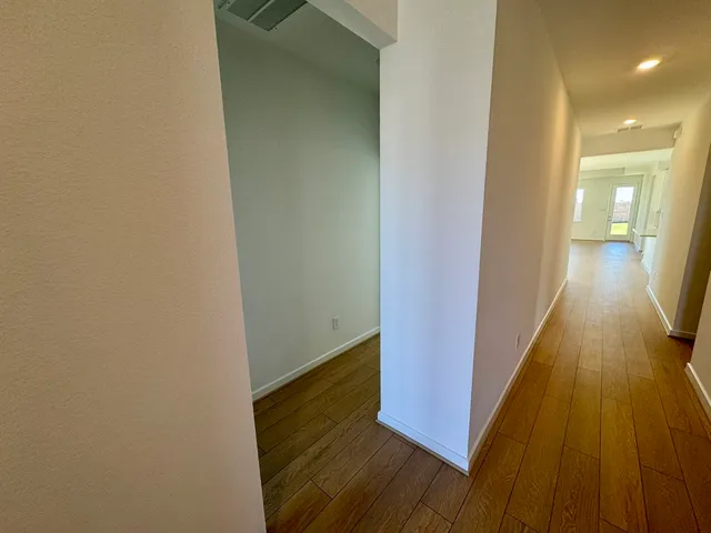 a view of a hallway with wooden floor
