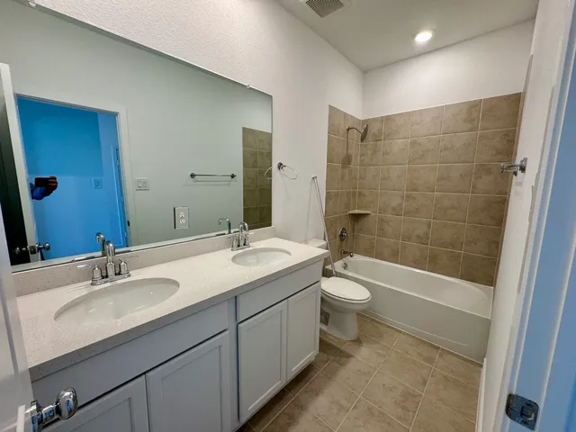 a bathroom with a double vanity sink toilet and shower
