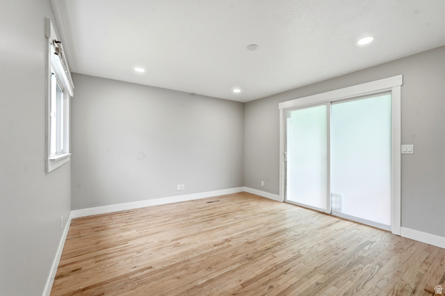 778 East 200 North Logan, UT 84321 - Photo 25 of 43 Spacious interior room featuring wood-finish flooring, light gray walls, white trim, recessed lighting, a large window, and a sliding glass door