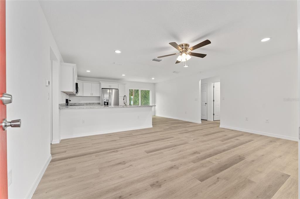 13119 Northeast 7th Loop Silver Springs, FL 34488 - Photo 11 of 51 a view of kitchen and empty room with a ceiling fan