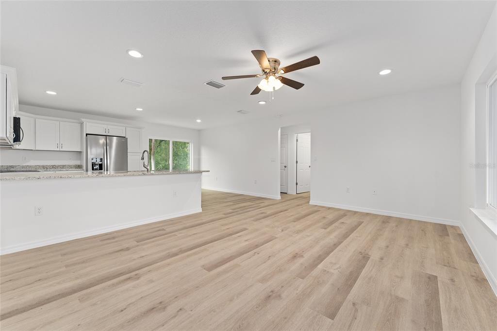 13119 Northeast 7th Loop Silver Springs, FL 34488 - Photo 16 of 51 a view of an empty room with kitchen appliances and a ceiling fan