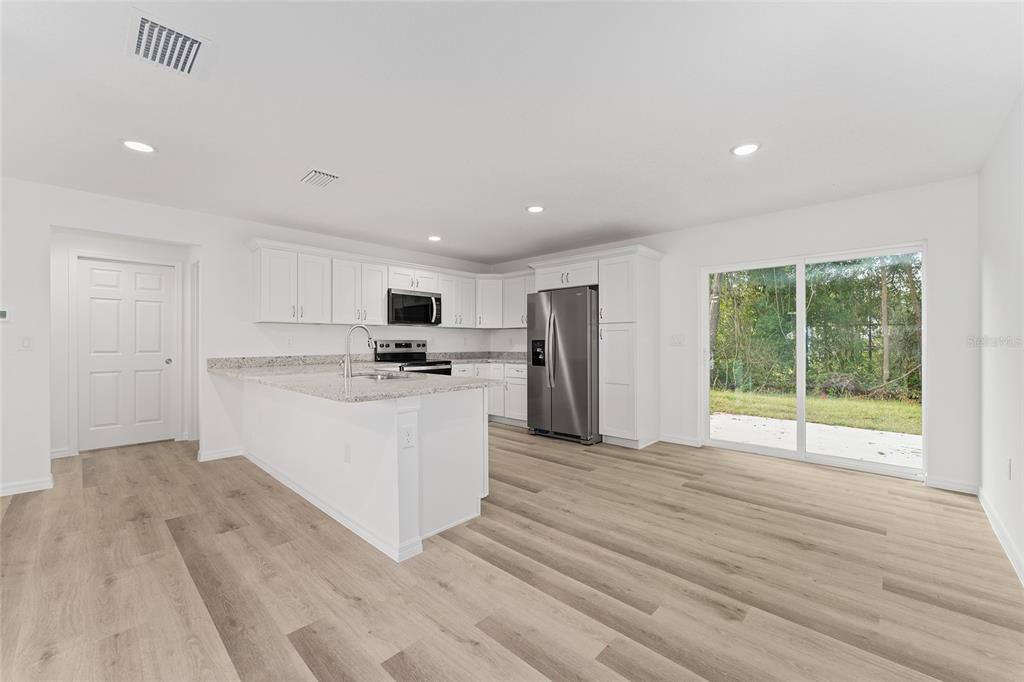 13119 Northeast 7th Loop Silver Springs, FL 34488 - Photo 17 of 51 a kitchen with stainless steel appliances granite countertop a refrigerator sink and cabinets