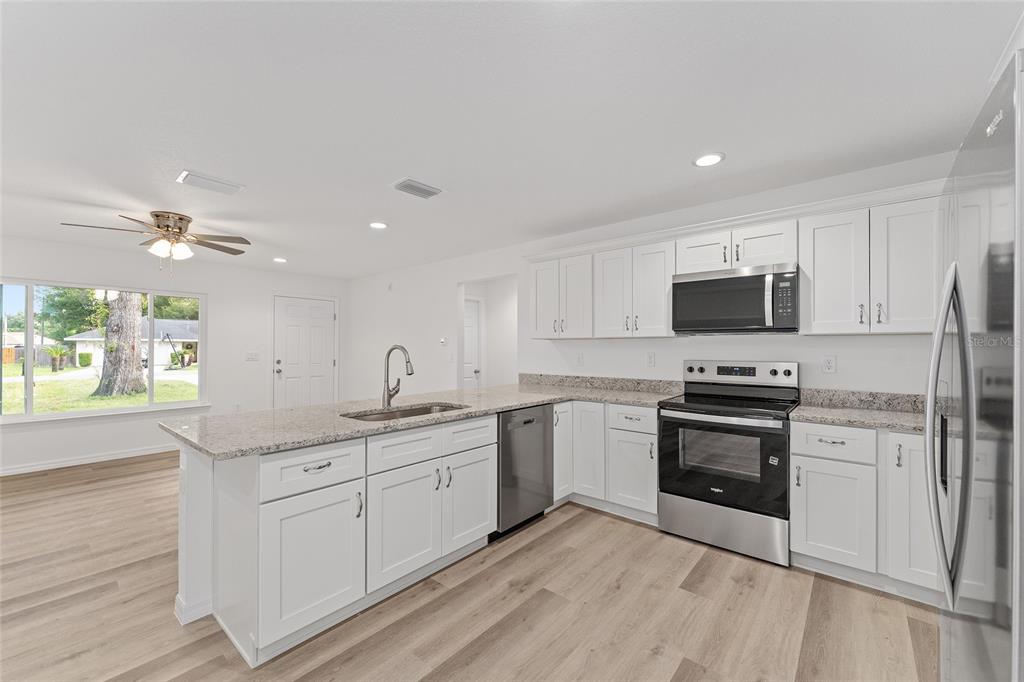13119 Northeast 7th Loop Silver Springs, FL 34488 - Photo 22 of 51 a kitchen with a sink cabinets and stainless steel appliances